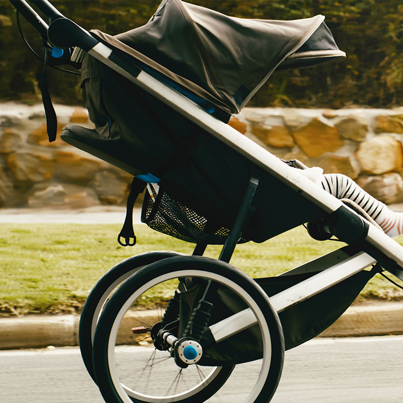 a close up of a modern pram moving quickly along a path